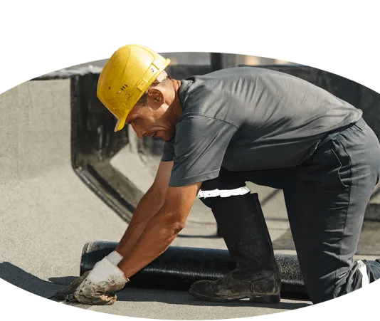 A man working on a roof with a hard hat in his job.