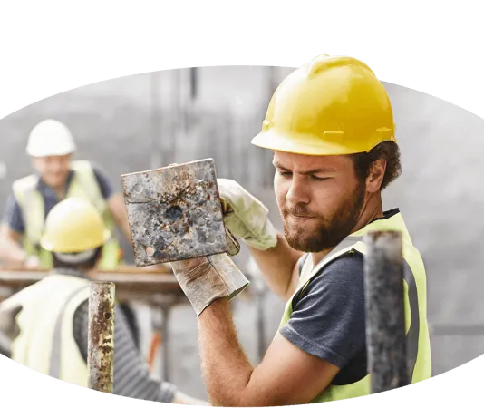 Ein Handwerker hält einen Betonblock.