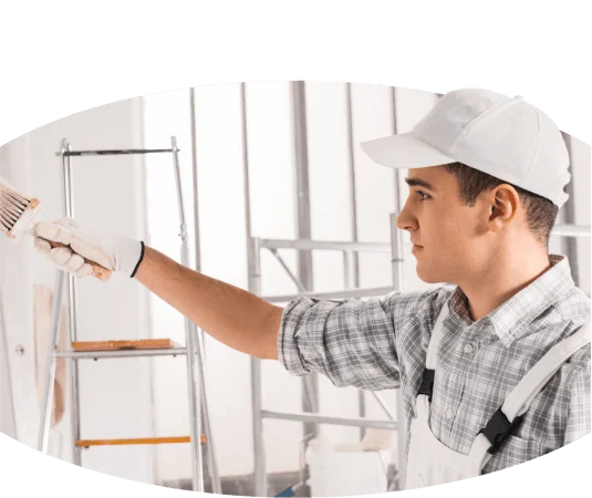 A handwerker holding a paint brush in a room.