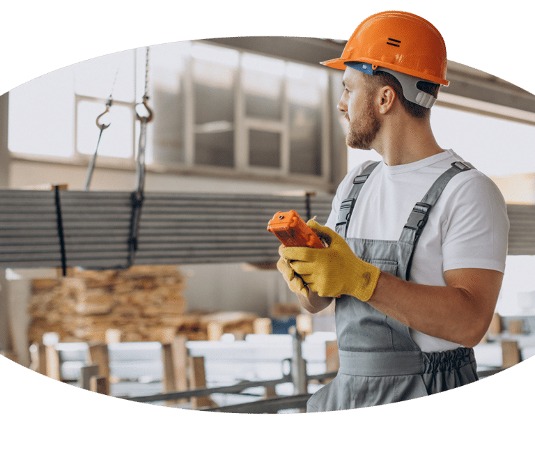 Ein Kranführer hält ein Werkzeug in einem Lagerhaus.