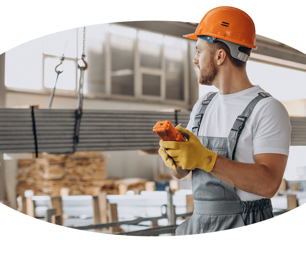 Ein Kranführer hält ein Werkzeug in einem Lagerhaus.