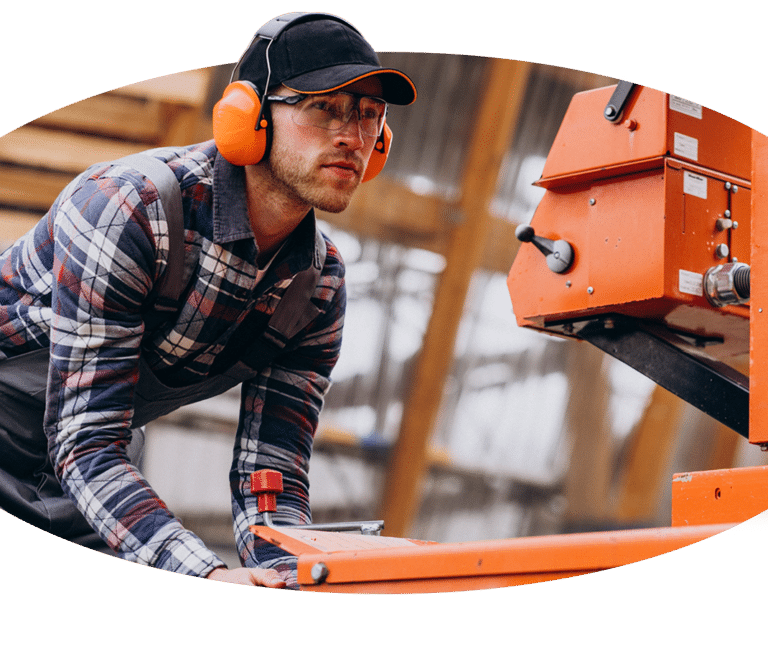 Ein Kranführer bedient eine Kreissäge in einer Fabrik.