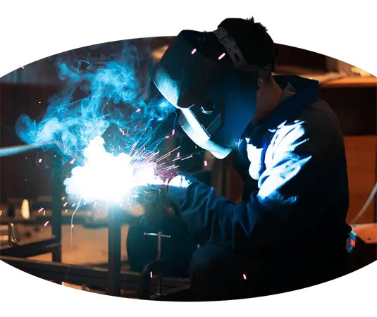 Ein auf Kranführerberufe spezialisierter Schweißer, der an einem Stück Metall arbeitet.